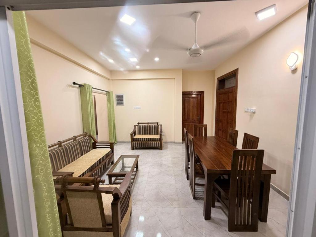 a room with a table and chairs and a table and benches at Wellness Residency in Colombo