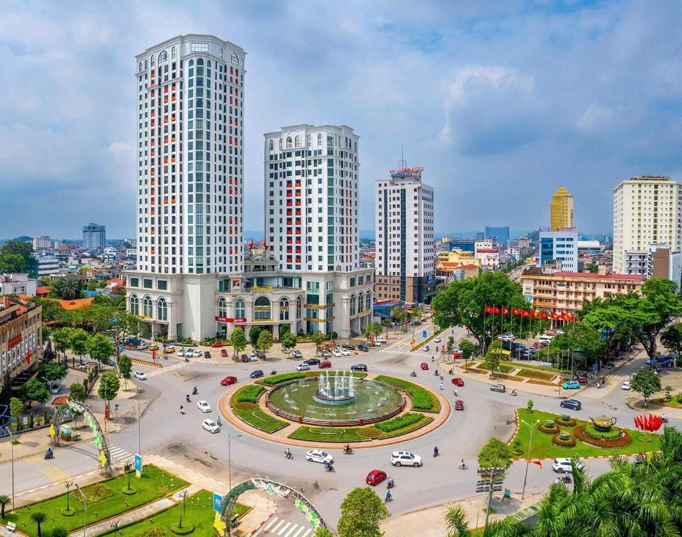 a city with tall buildings and a park with a fountain at Prime Hotel in Thái Nguyên