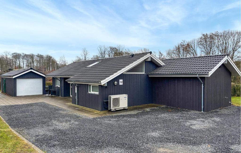 a black house with a garage at Lovely Home In Haderslev With Sauna in Haderslev