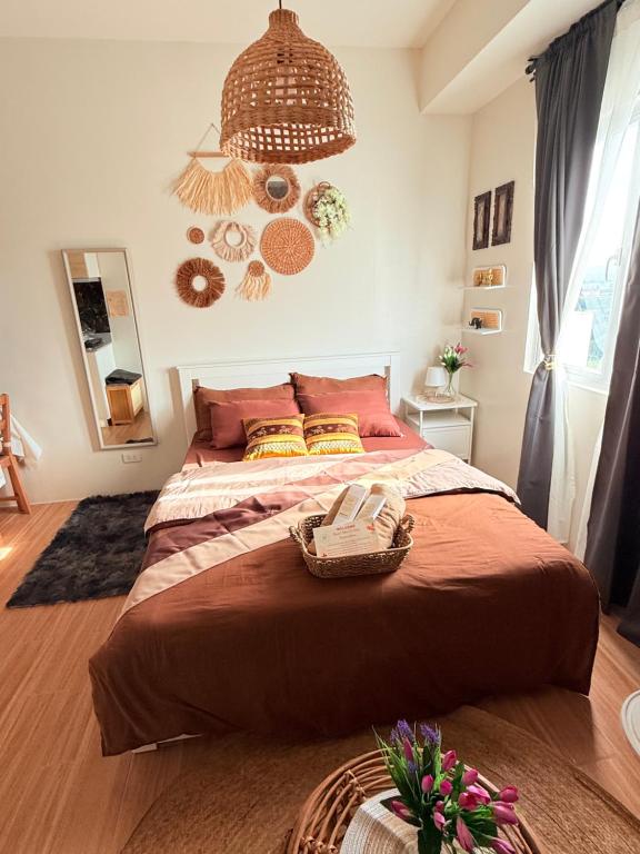 a bedroom with a large bed with a basket on it at Baan Mai Condo Staycation in Biñan