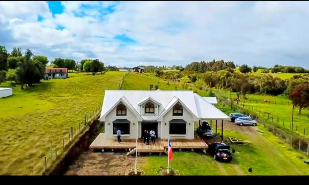 an aerial view of a white house in a field at Hospedaje Fer-Mar in Castro
