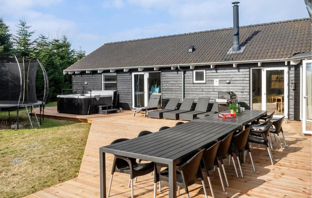 a patio with a table and chairs and a grill at Amazing Home In Idestrup With Sauna in Bøtø By