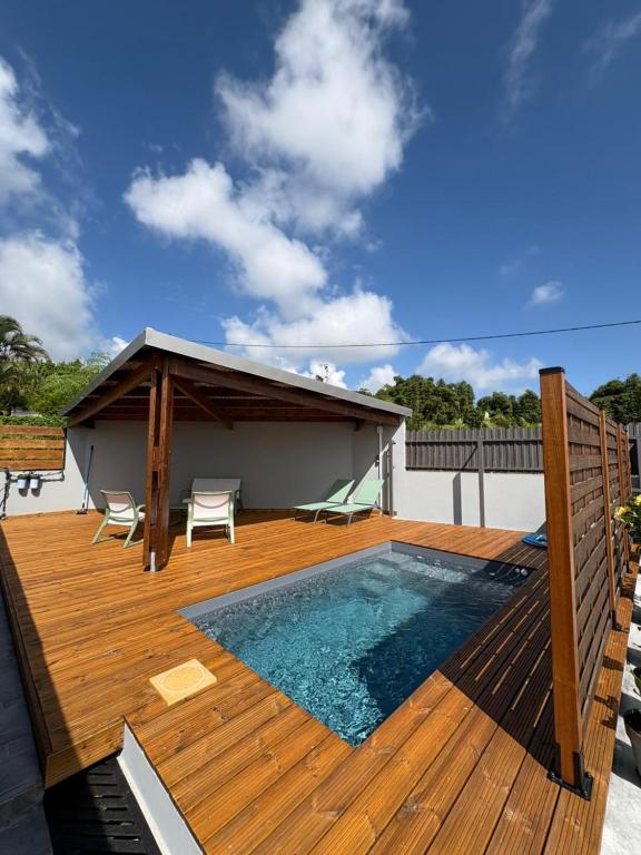 a deck with a swimming pool and a pavilion at Villa hibiscus in Sainte-Suzanne