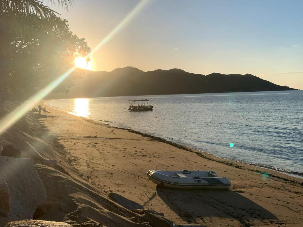 a boat sitting on the beach with the sun setting at Horseshoe Haven in Horseshoe Bay