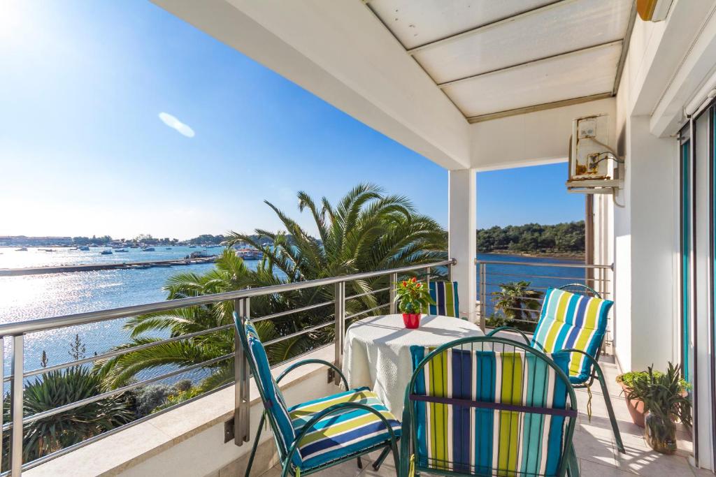 d'un balcon avec une table et des chaises donnant sur l'océan. dans l'établissement Marija Marković Medulin A15, à Medulin