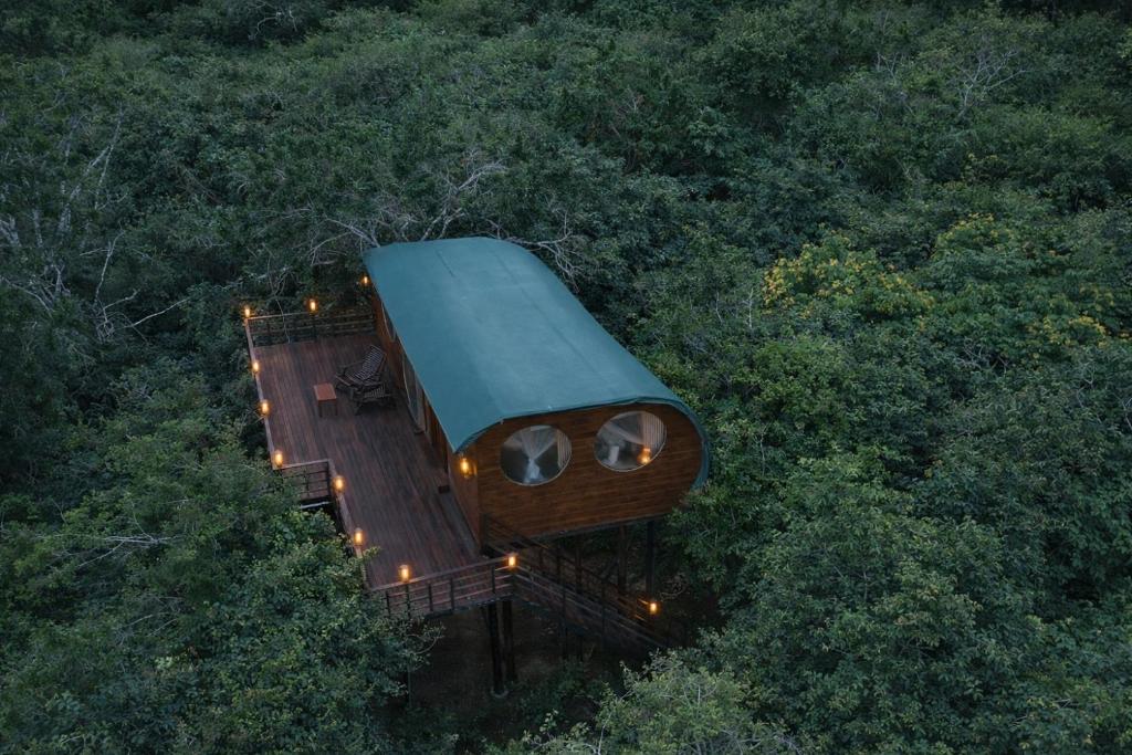 a tree house with a green roof in the trees at Leopard Nest in Yala in Yala