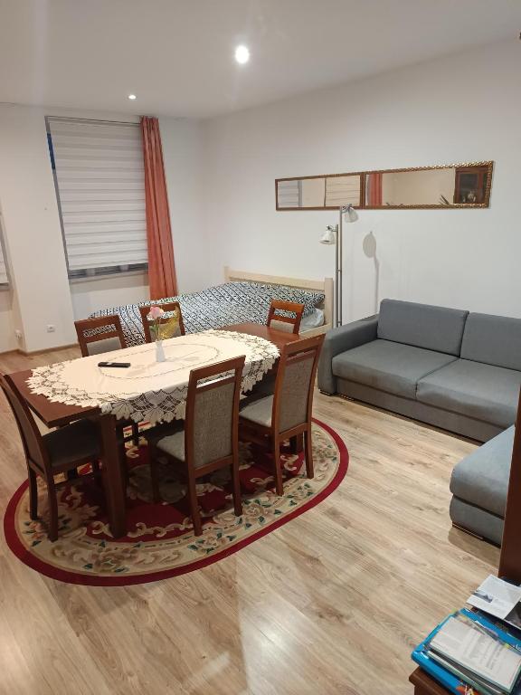 a living room with a table and chairs and a couch at Rafaelo Władycze 17/4 in Przemyśl
