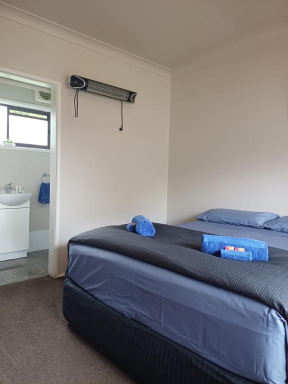 a bedroom with a bed and a bathroom with a sink at Wattleview in Lithgow