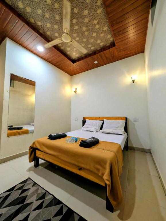 a bedroom with a large bed with a wooden ceiling at Hotel Rukmini Residency, Kolhapur in Kolhapur