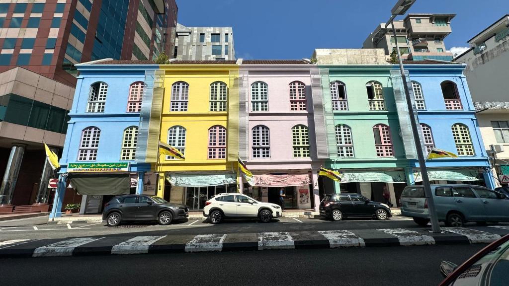 a colorful building with cars parked in front of it at First Avenue Male Hostel BSB in Bandar Seri Begawan