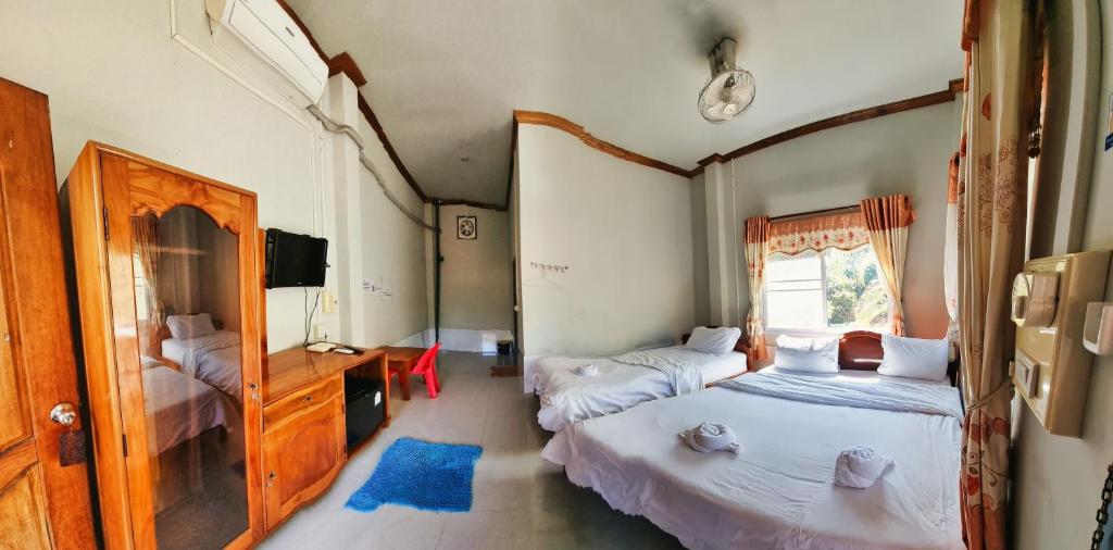 a bedroom with two beds and a sink and a mirror at Beyond Pub guest House and Hotel in Ban Tayun