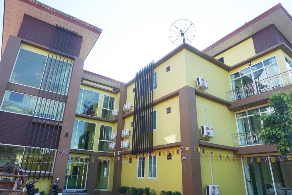 un edificio giallo con un mulino a vento sopra di esso di Honey Hotel Chiang Saen a Chiang Saen