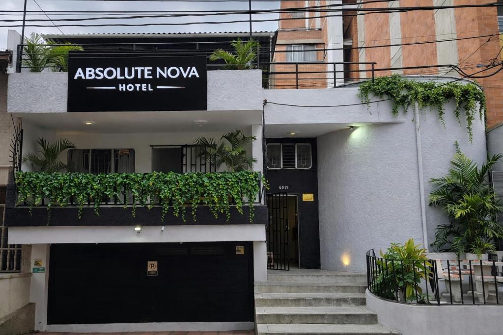 a white building with a black door and a balcony at Absolute Nova Hotel in Medellín