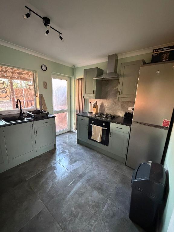 a kitchen with a sink and a refrigerator at Jerry's lane 3 bed house free parking free wifi in Birmingham