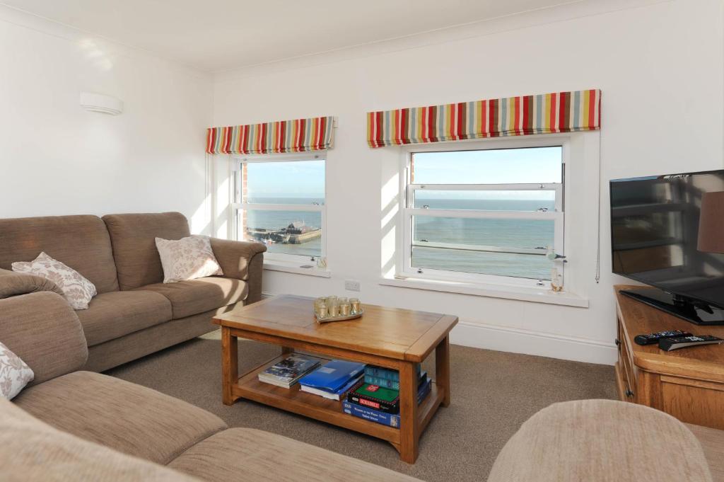 ブロードステアーズにある2 Bed beach front apartment with spectacular views overlooking Viking Bayのリビングルーム(ソファ、テーブル付)