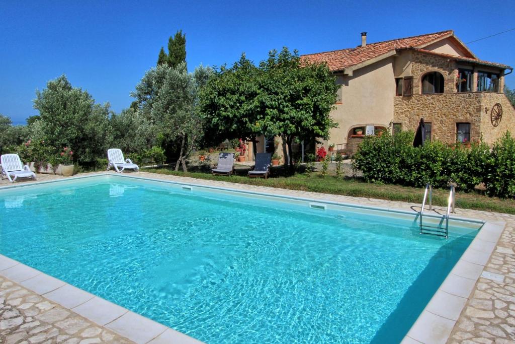 a swimming pool in front of a house at Guardistallo by PosarelliVillas in Guardistallo