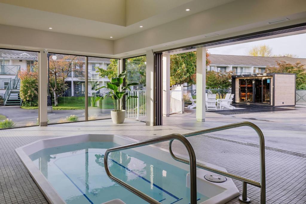 an indoor hot tub in a house with a patio at Balcomo, a Ramada by Wyndham in Penticton