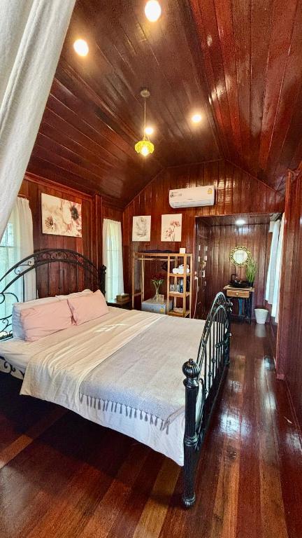 a bedroom with a large bed in a wooden ceiling at Rang Robin Farmstay with swimming pool in Ban Wang Muang