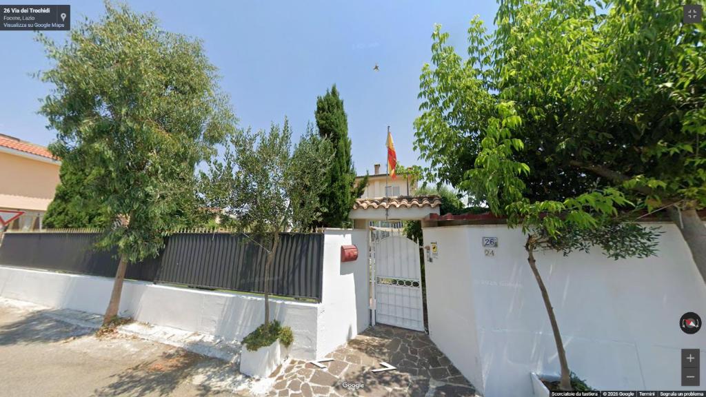 a white fence with a gate and two trees at Alloggio Turistico in Focene