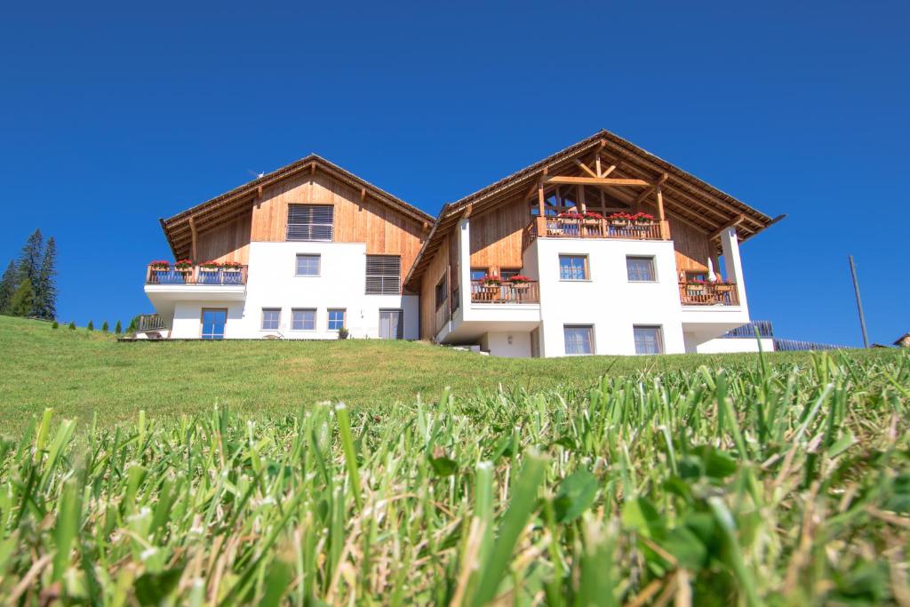 una casa en la cima de una colina con césped en Agriturismo Maso Runch, en Badia