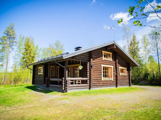 a small log cabin in a field of grass at Artunpirtti in Keuruu