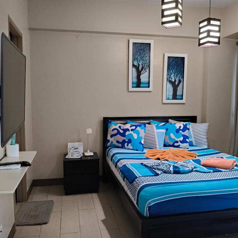a bedroom with a bed with blue and white sheets at LDN Secret Crib -Two palm tree across NAIA Terminal 3 in Manila