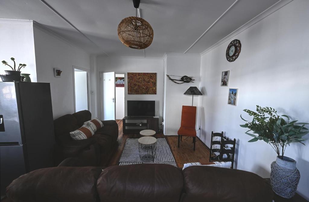a living room with a couch and a table at Oasis Simon's town cape town in Glencairn