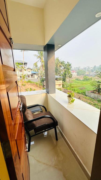a chair in a room with a large window at Sign Valley in Cochin