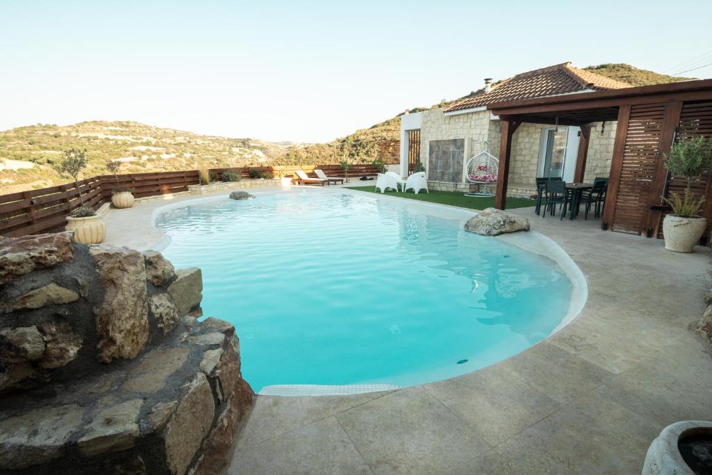 a large swimming pool in a yard with a patio at Villa Flam in Kholi