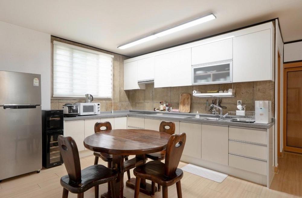 a kitchen with a table and chairs and a refrigerator at Jeonju Dalbitsori Pension in Jeonju