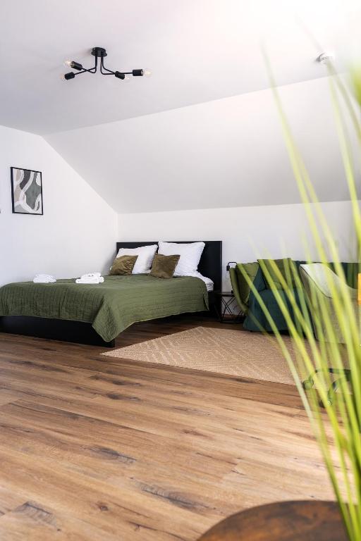 a bedroom with a bed and a wooden floor at Apartment Manu in Inzlingen
