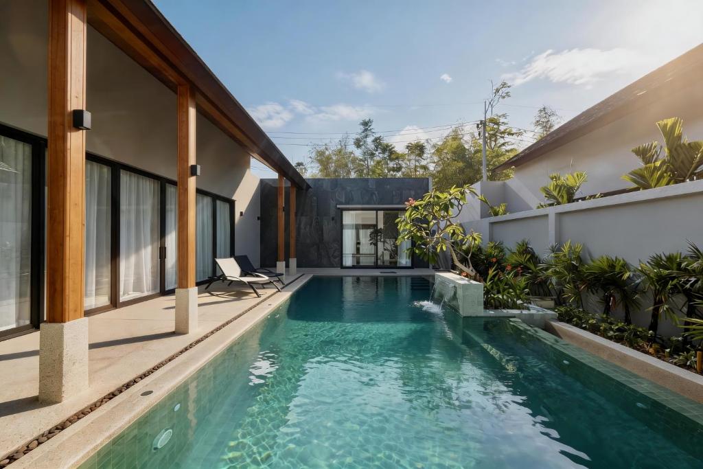 an infinity pool in the backyard of a house at Bougainvillea Luxury Pool Villas in Ban Pak Lak