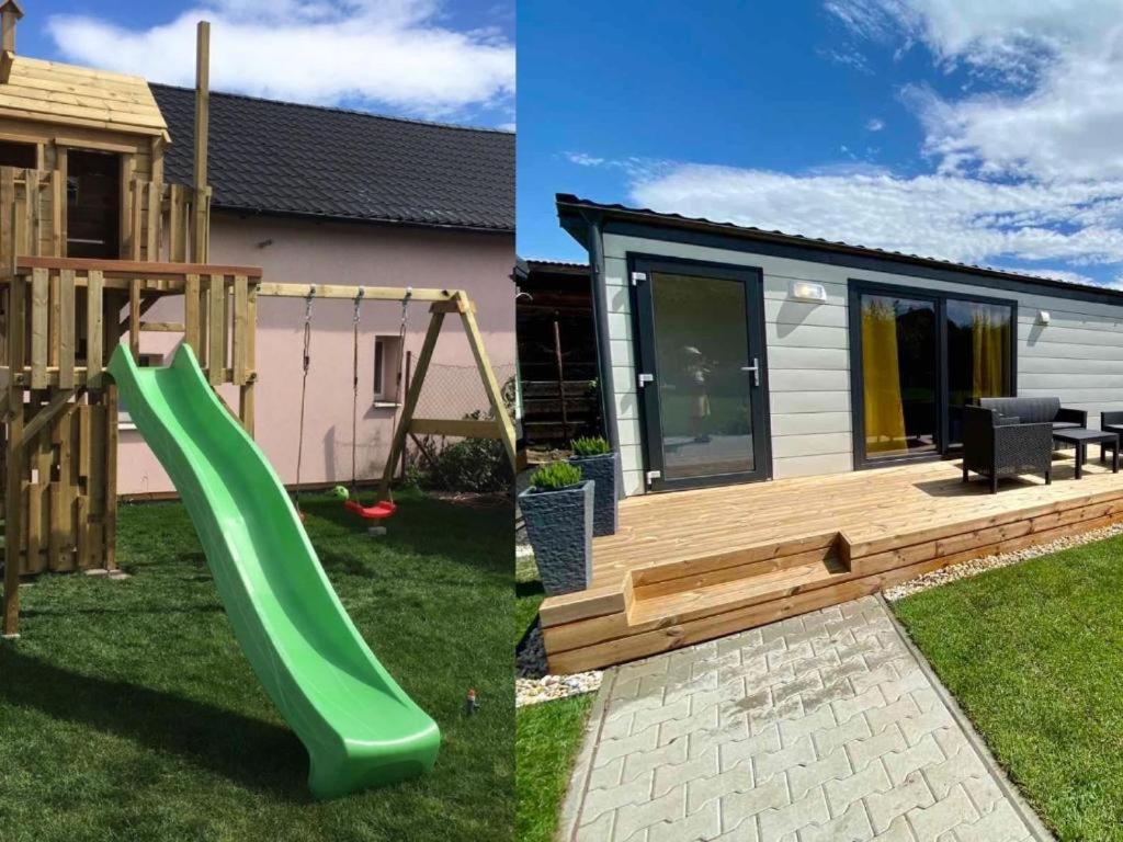 a green slide in a yard next to a tiny house at Cyprianus village in Poprad