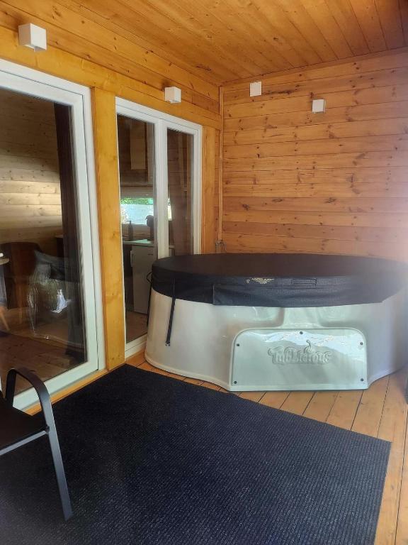 a room with a large tub in a wooden cabin at Woodbox Noszvaj in Noszvaj