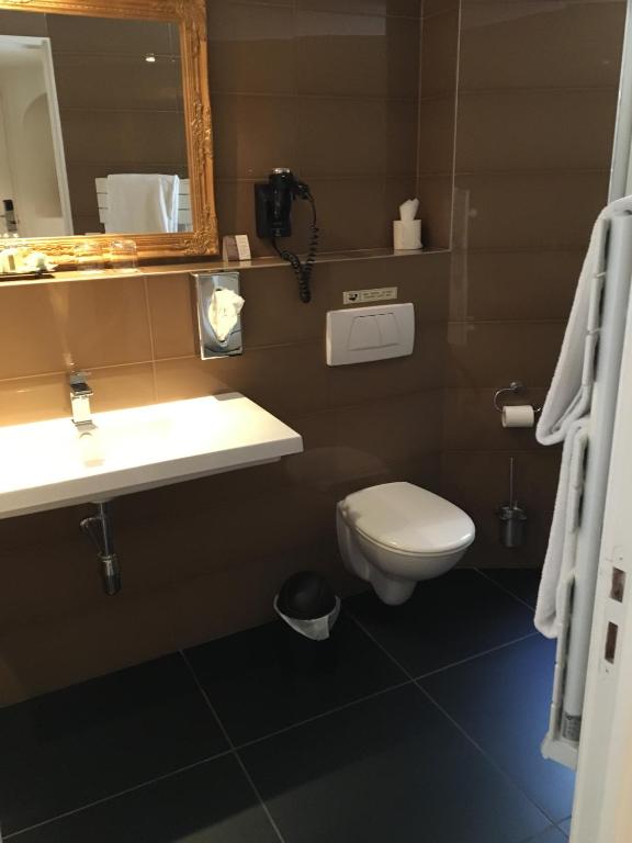 a bathroom with a toilet and a sink and a mirror at Hôtel La Villa Cannes in Cannes