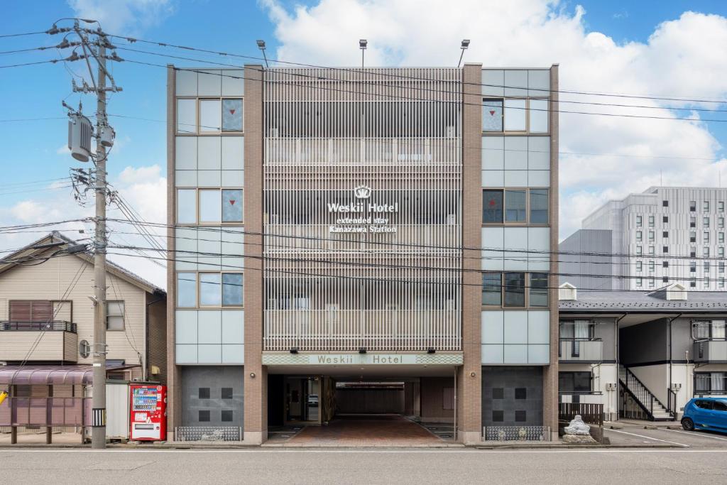 a large building with a sign on the front of it at WeskiiHotel in Kanazawa