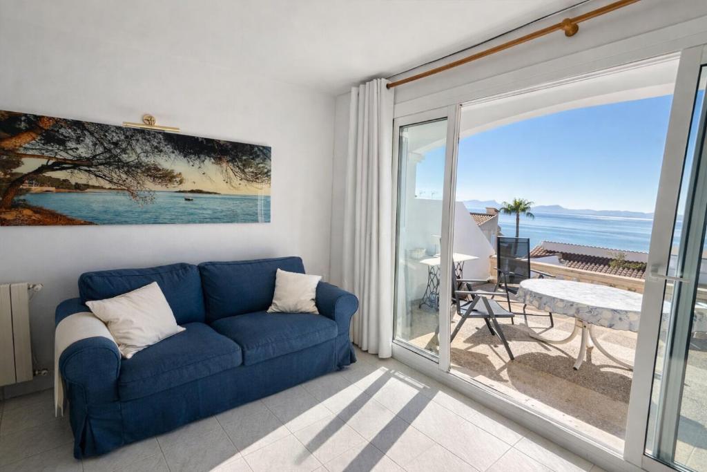 a blue couch in a living room with a view of the ocean at Auba Mar - Alcudia Sea View in Alcudia