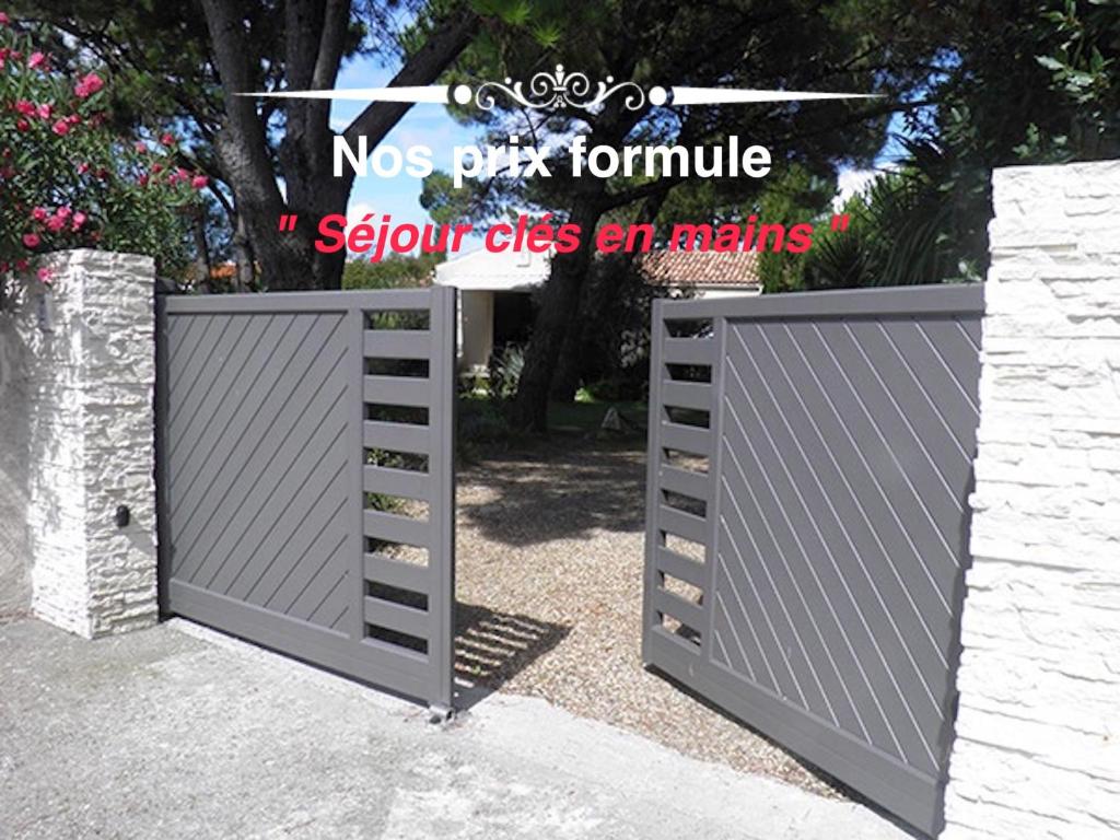a pair of gates in a driveway at Les Fleurs De Lys, Villa Chic L'enclos Des Lys, Proche de la Mer in Saint-Georges-dʼOléron