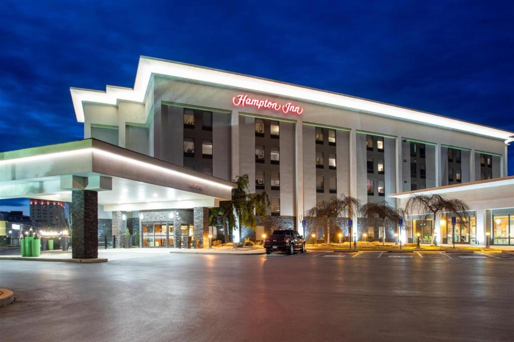 a building with a car parked in front of it at Hampton Inn Williamsport in Williamsport