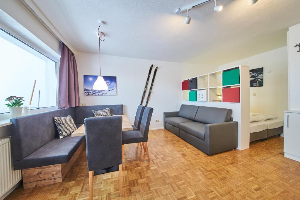 ein Wohnzimmer mit einem Tisch, Stühlen und einem Sofa in der Unterkunft Appartement Relax & Sport in Saalbach-Hinterglemm