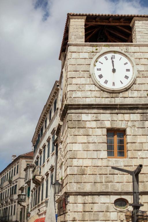 a clock tower on the side of a building at Step to Kotor Bay Old Town in Kotor