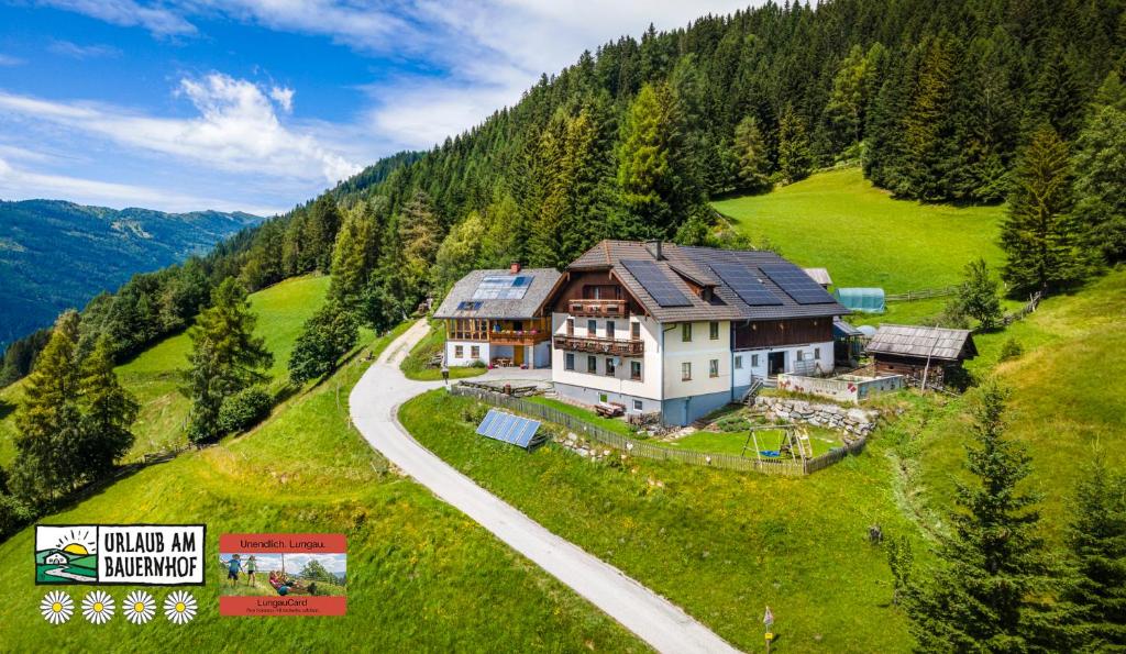 a large house on a hill with a road at Ferienhaus Krametergut in Sankt Michael im Lungau