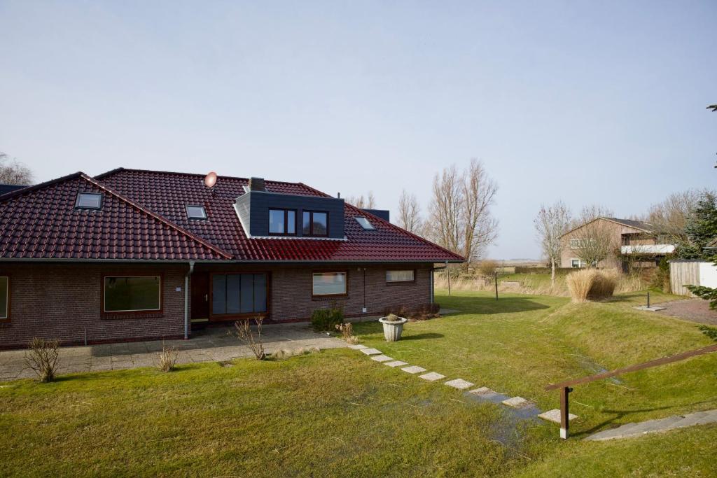 a house with a red roof and a yard at England 5 in Nordstrand