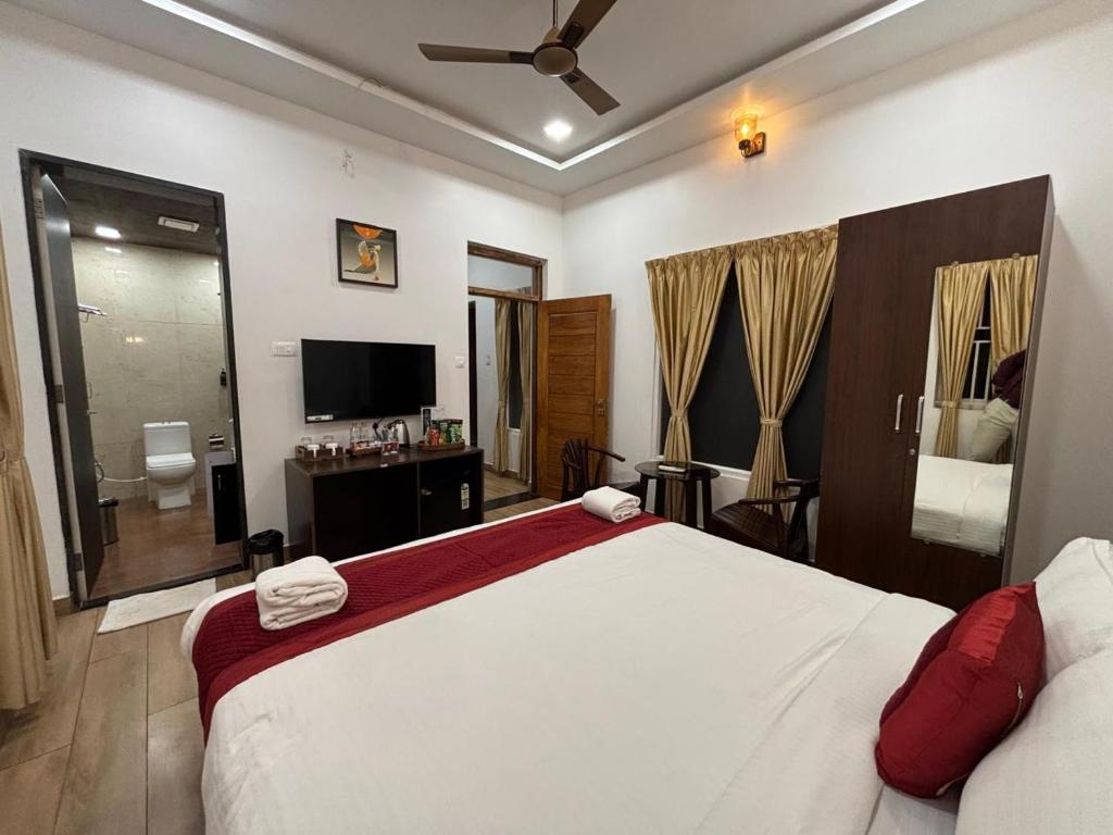 a bedroom with a large white bed and a television at Èden Ember Castle in Gokarna