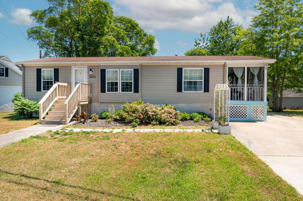a house with a porch and a yard at One Peace Cottage in Deep Hole
