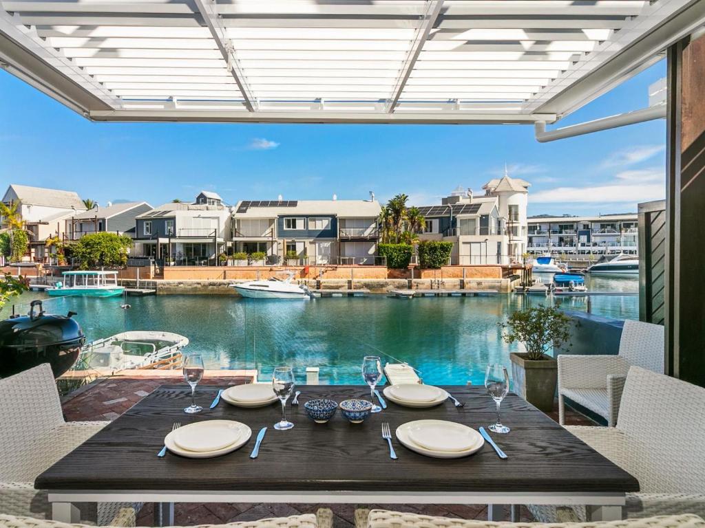 a table with plates and wine glasses on a balcony at KnysnaQuays 4 in Knysna