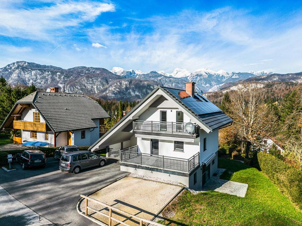 a house with a car parked in a parking lot at Apartments CRYSTAL AURA in Bohinj