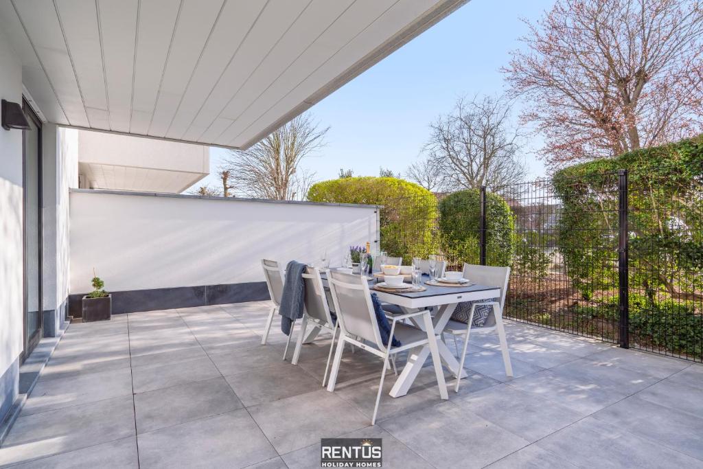 a patio with a table and chairs on it at Thyline One - new spacious apartment for 8 persons in Nieuwpoort