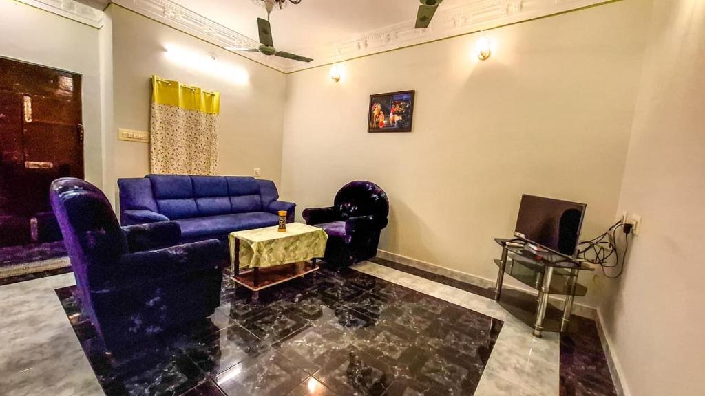 a living room with a blue couch and a tv at Radiance Crystal in Pondicherry