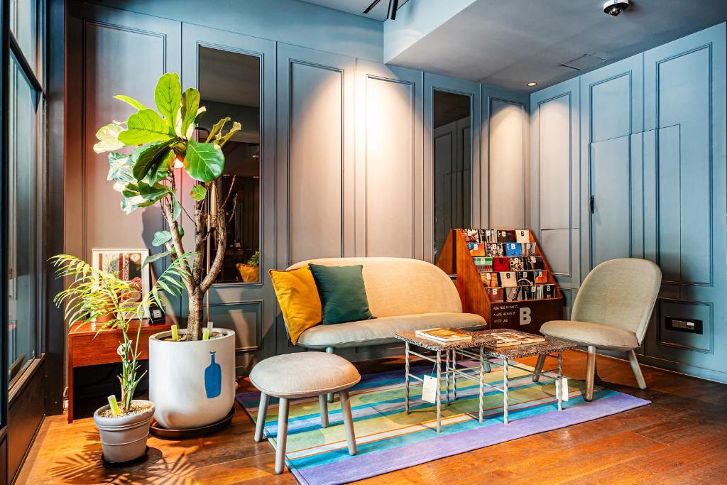 a room with a couch and two chairs and a table at Sillim Dominique Hotel in Seoul